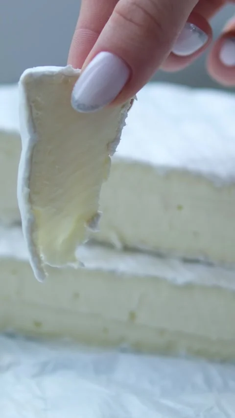 Cheese with white mold cheese brie piece in the hands of a girl delicious fresh Stock Footage 301314365