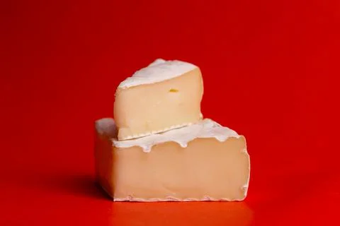 Cheese with white mold on a red background close-up Stock Photos