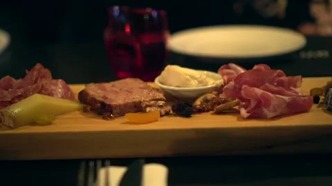 Cheeseboard variety of cheeses and cured meat wood platter wine appetizer 4k Video stock 331799286