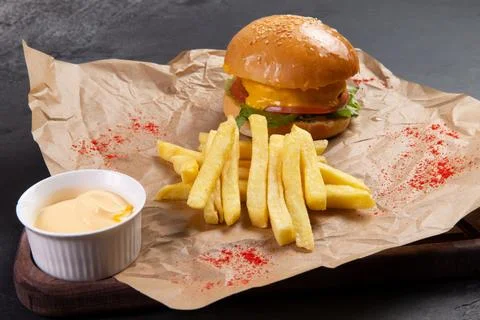 Cheeseburger and fries. On a dark background. Stock Photos