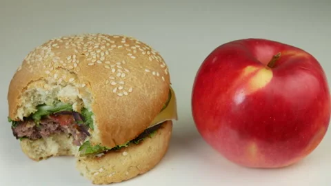Cheeseburger and red apple 1 Stock Footage 241808194