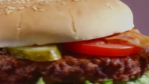 Cheeseburger with bacon turns close up Stock Footage 81489407