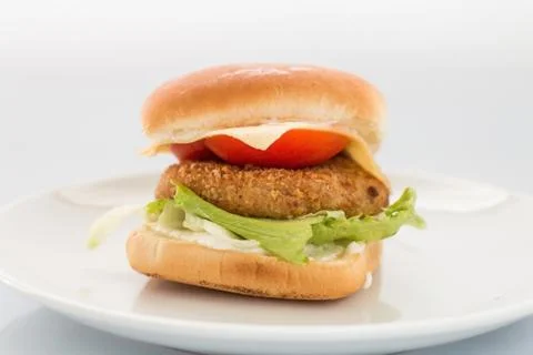 Cheeseburger with beef cutlet, bacon, tomatoes and cheese slices, seasoned wi Stock Photos