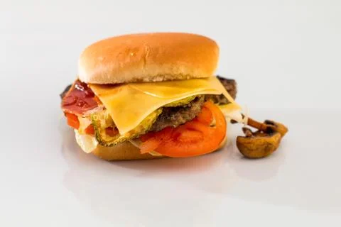 Cheeseburger with beef cutlet, bacon, tomatoes and cheese slices, seasoned wi Foto stock