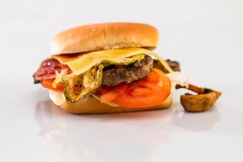 Cheeseburger with beef cutlet, bacon, tomatoes and cheese slices, seasoned wi Foto stock