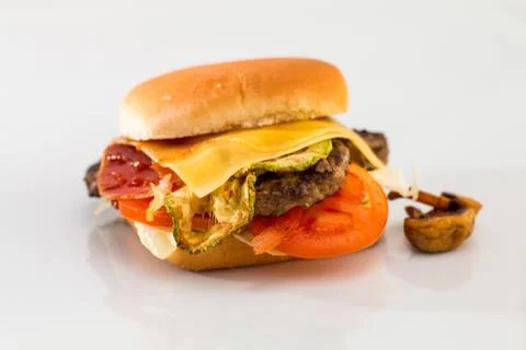 Cheeseburger with beef cutlet, bacon, tomatoes and cheese slices, seasoned wi Foto stock