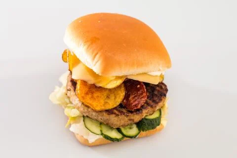 Cheeseburger with beef cutlet, bacon, tomatoes and cheese slices, seasoned wi Stock Photos