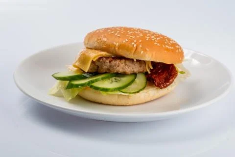 Cheeseburger with beef cutlet, bacon, tomatoes and cheese slices, seasoned wi Stock Photos