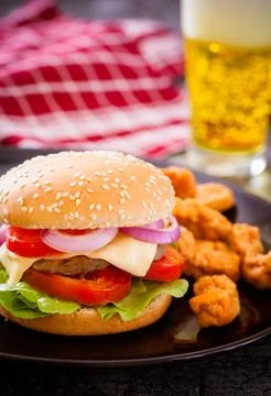 Cheeseburger with beer in bar Stock Photos