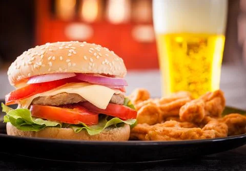 Cheeseburger with beer in bar Stock Photos