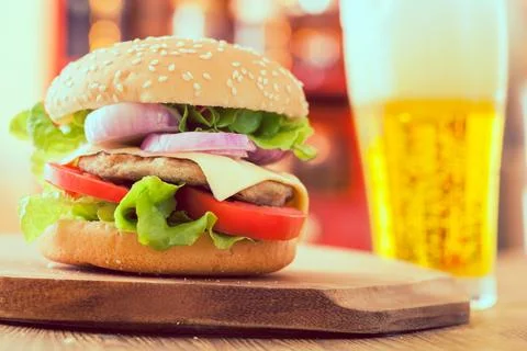 Cheeseburger with beer in bar Stock Photos