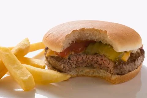 Cheeseburger (with a bite taken) with chips Stock Photos