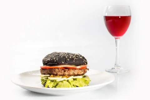 Cheeseburger with black bread, beef cutlet, bacon, tomatoes and cheese slices Stock Photos