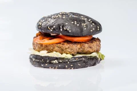 Cheeseburger with black bread, beef cutlet, bacon, tomatoes and cheese slices Stock Photos