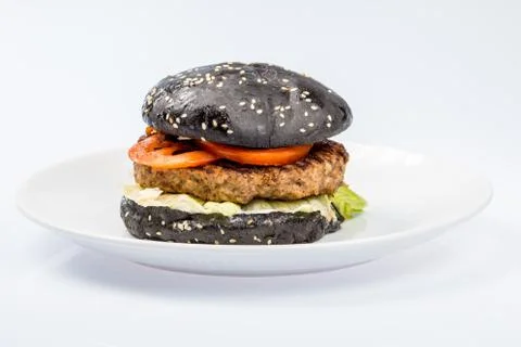 Cheeseburger with black bread, beef cutlet, bacon, tomatoes and cheese slices Stock Photos