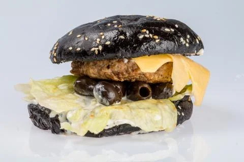 Cheeseburger with black bread, beef cutlet, bacon, tomatoes and cheese slices Foto stock