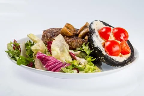 Cheeseburger with black bread, beef cutlet, bacon, tomatoes and cheese slices Stock Photos