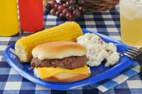 Cheeseburger with corn on the cob Stock Photos