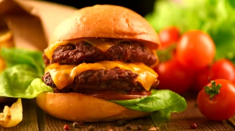 Cheeseburger on fresh buns with succulent beef patties and salad ingredients Stock Footage 50048603
