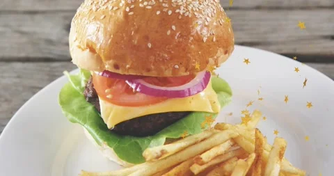 Cheeseburger with fries centered as camera pulling back and stars drifting, Stock Footage 323272055