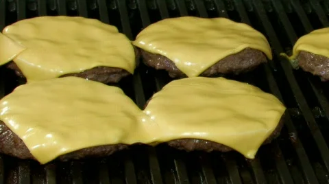 Cheeseburgers cooking on a barbecue grill Stock Footage