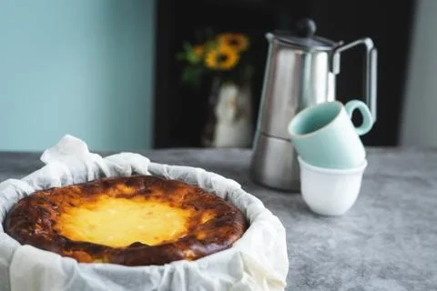 Cheesecake in marble background with coffee maker in the background. Stock Photos