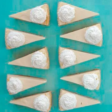 Cheesecake pattern, servings of cheesecake on a blue background top view 库存照片