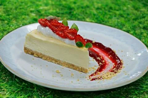 Cheesecake portion with raspberry and crumble on a green background Stock Photos