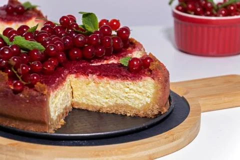 Cheesecake with red currant and mint on wooden board. Top view. Stock Photos