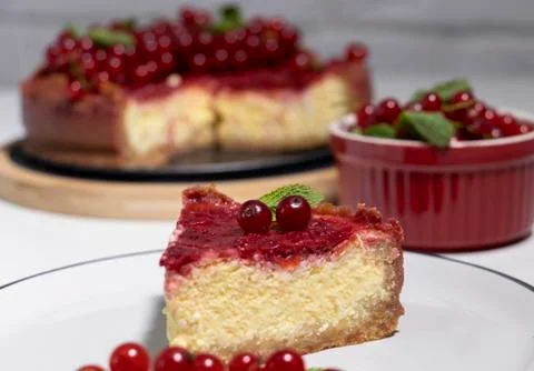 Cheesecake with red currant and mint on wooden board. Top view. Stock Photos
