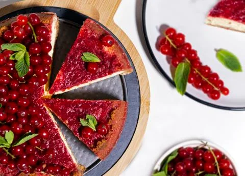 Cheesecake with red currant and mint on wooden board. Top view. Stock Photos