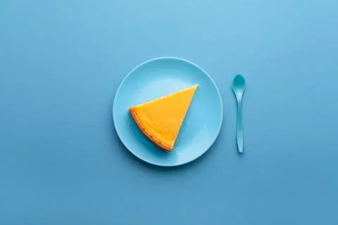 Cheesecake slice on blue plate. One piece of cheese cake on table Stock Photos