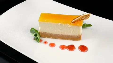 Cheesecake slice, served in luxury restaurant, decorated with caramelized orange Stock Footage 90659813