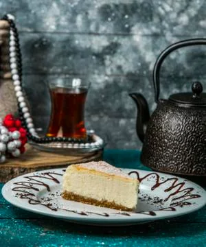 Cheesecake slice in white plate served with black tea Stock Photos