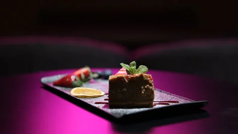 Cheesecake topped with raspberry syrup.Sweet dessert with strawberries blueberri Video stock 239908612