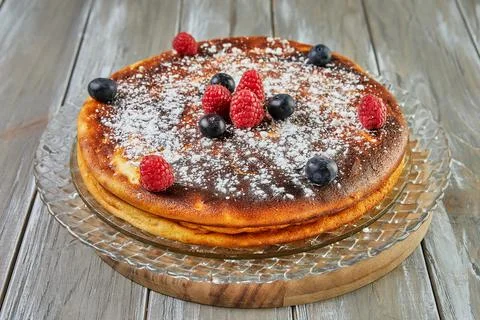 Cheesecake without dough with red fruit syrup and raspberries and blueberries Фото