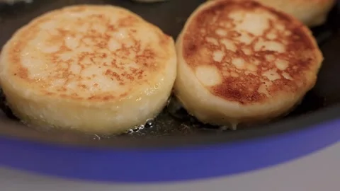 Cheesecakes are fried in a frying pan Stock Footage 318463711