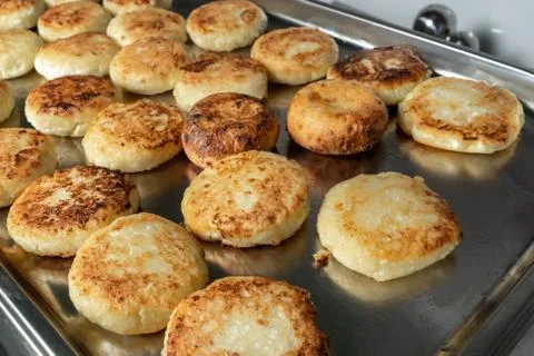 Cheesecakes on a baking sheet, cook in the dining room. 스톡 사진