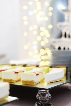 Cheesecakes on a mirror tray stand on a buffet table against the background.. 写真素材