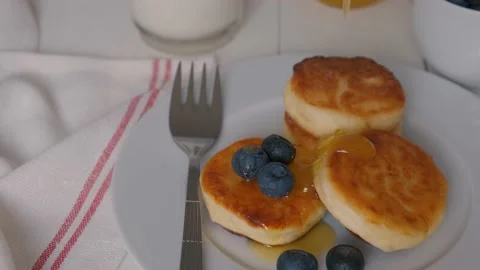 Cheesecakes mlm cottage cheese served with blueberries and honey Stock Footage 163646767