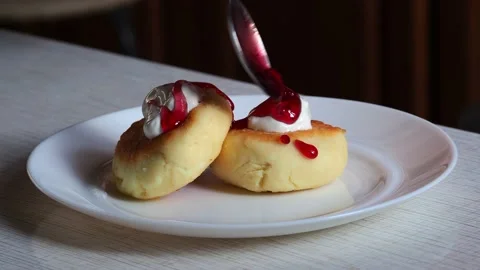 Cheesecakes on a plate pour jam. Stock Footage 229889014