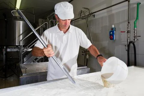 Cheesemaker pours rennet Stock Photos