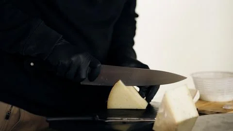 Cheesemaker slicing artisan cheese with a knife Stock Photos