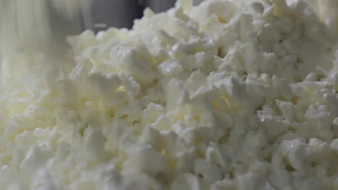 Cheesemaking. Close up of Freshly Made Curd Falling into a Container. Dairy Food Stock Footage 265917556