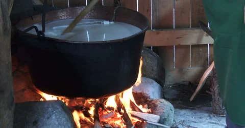 Cheesemaking of Mountain Cheese in a log cabin. Video stock 69010544