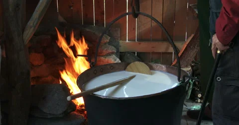Cheesemaking of Mountain Cheese in a log cabin. Video stock 69038712