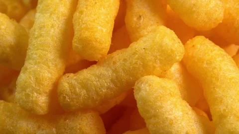 Cheesy corn chips rotates closeup. Crispy cheese snack. Crispy fluffy corn Stock Footage 256717328