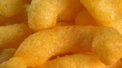Cheesy corn chips rotates in macro. Crispy cheese snack. Crispy fluffy corn Stock Footage 256717282