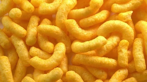 Cheesy corn chips rotates on plate top view. Crispy cheese snack. Crispy fluffy Stock Footage 256717809