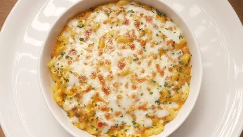 Cheesy macaroni pasta with ground meat and herbs slowly rotating in a white bowl Stock-Footage 339153048
